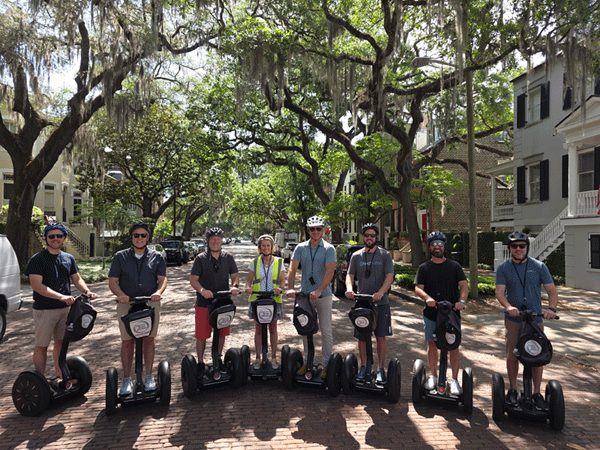 Cohort members on a guided Segway tour under oak trees draped in Spanish moss